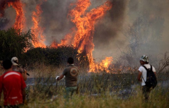 People are pictured during a forest fire in San Carlos town, at the country's central-south regions,