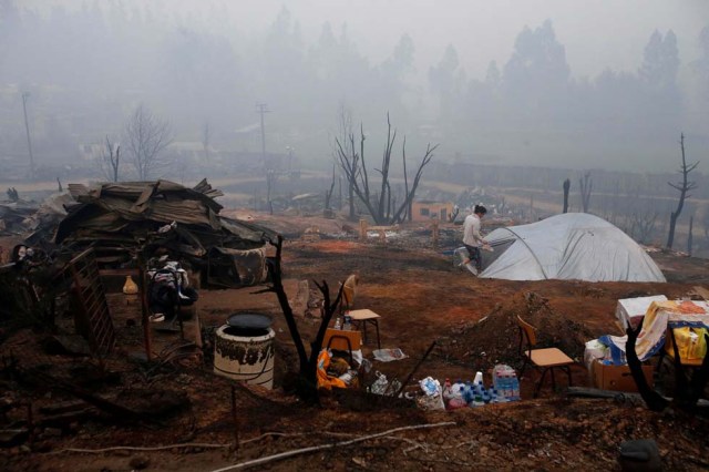 A tent is pictured among the remains of burned houses after a wildfire at the country's central-south regions in Santa Olga