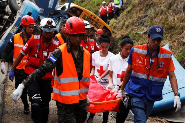 Rescue workers and members of the red cross are carrying a body after a crash between a bus and a truck on the outskirts of Tegucigalpa, Honduras, February 5, 2017.  REUTERS/Jorge Cabrera