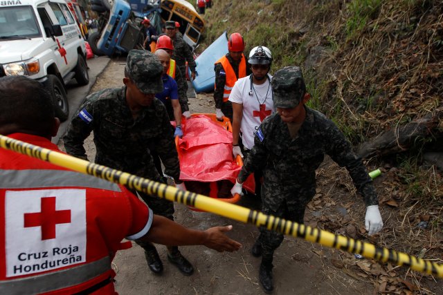 Soldiers and members of the red cross carry a dead body after a crash between a bus and a truck on the outskirts of Tegucigalpa, Honduras, February 5, 2017.  REUTERS/Jorge Cabrera