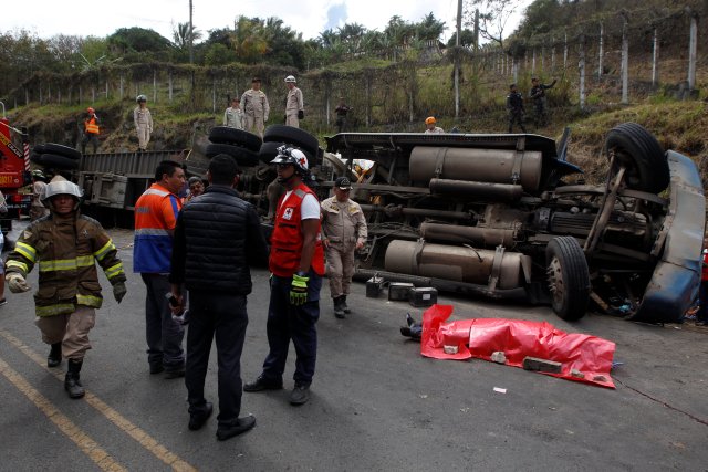 Rescue workers and members of the Red Cross stand next to a dead body after a crash between a bus and a truck on the outskirts of Tegucigalpa, Honduras, February 5, 2017.  REUTERS/Jorge Cabrera