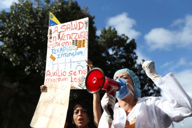 A woman shouts slogans during a rally of workers of the health sector and opposition supporters, due to the shortages of basic medical supplies and against Venezuelan President Nicolas Maduro's government in Caracas, Venezuela February 7, 2017. The placard reads, "The health in Venezuela is in intensive care". REUTERS/Carlos Garcia Rawlins