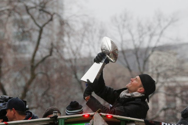 New England Patriots quarterback Tom Brady holds up one of the team's five Vince Lombardi trophies during their victory parade through the streets of Boston after winning Super Bowl LI, in Boston