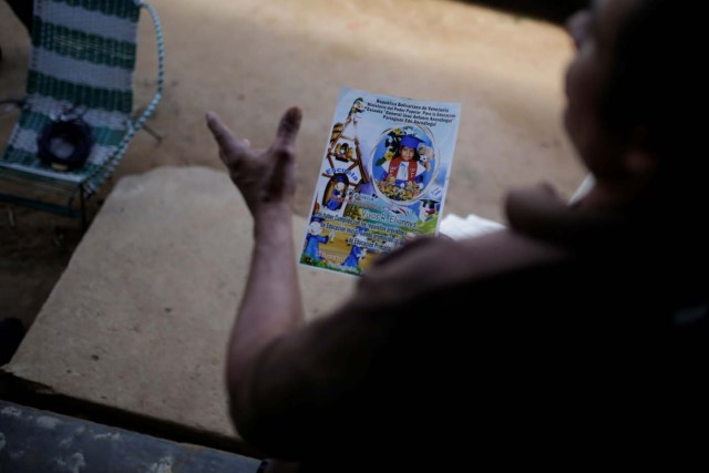 Tulio Medina holds a photo of his daughter Eliannys Vivas, who died from diphtheria, at the front porch of his home in Pariaguan, Venezuela January 26, 2017. Picture taken January 26, 2017. REUTERS/Marco Bello