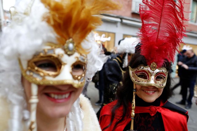 Masked revellers pose during the Venice Carnival in Venice, Italy February 11, 2017. REUTERS/Tony Gentile