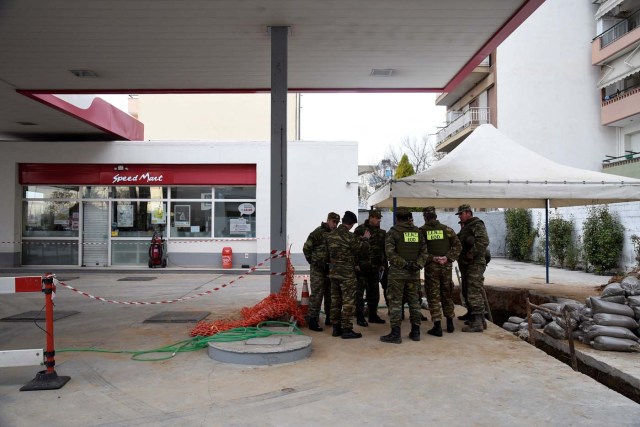 Military personnel of the Hellenic Army's Explosives Ordnance Disposal (EOD) team discuss before an operation to defuse a 250 kg World War Two bomb that was found during excavation works at a gas station in the northern city of Thessaloniki, Greece, February 12, 2017. REUTERS/Alexandros Avramidis