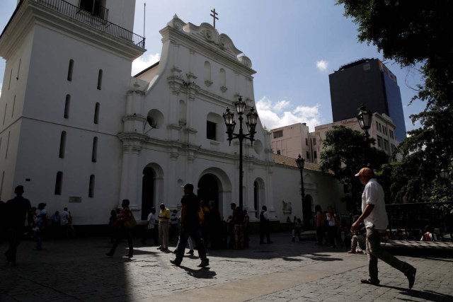 People walk past the Caracas Cathedral at Plaza Bolivar square in downtown Caracas, Venezuela February 6, 2017. Picture taken February 6, 2017. REUTERS/Marco Bello