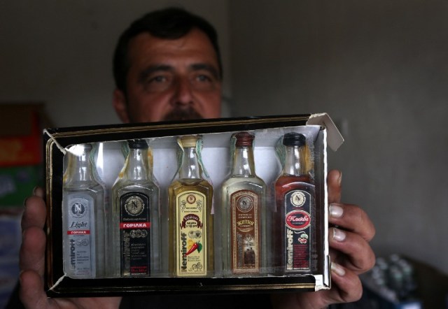 Wissam Ghanem, an Iraqi man from the Yazidi community, displays alcohol for sale at his shop in the town of Bashiqa, some 20 kilometres north east of Mosul, on February 17, 2017. Ghanem, who returned to the town of Bashiqa after Kurdish Peshmerga forces retook the town from Islamic State (IS) group jihadists, re-opened his alcohol business which was strictly forbidden under the rule of the Islamists, after finding cans of beer and bottles of spirits in abandoned houses formerly occupied by IS fighters. / AFP PHOTO / SAFIN HAMED
