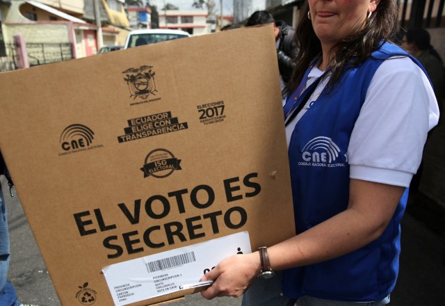 Worker of the Electoral National Council carry electoral materials during a program for people with disabilities to vote in advance in the Sunday's presidential election, in Quito, Ecuador, February 17, 2017. The sign reads; 'the vote is secret'.  REUTERS/Mariana Bazo