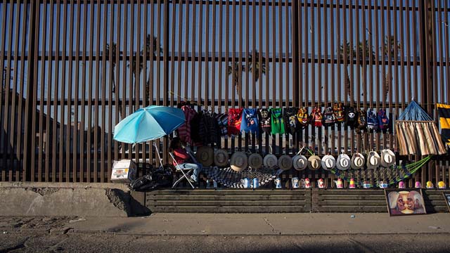 Vendedores mexicanos utilizan la valla fronteriza como escaparate para exhibir sus artículos.