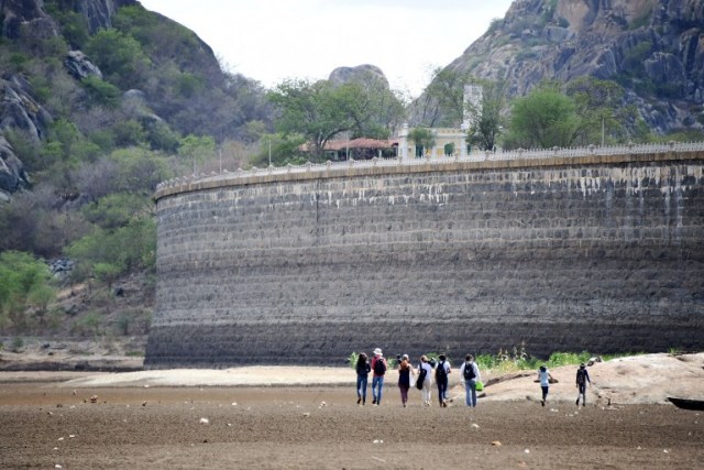 Researchers at the Federal University of Ceara walk at the dry Cedro reservoir in Quixada, Ceara State, on February 8, 2017. The situation of Brazil's oldest reservoir sumps up the devastiting effects -human and environmental- of the worst drought of the century in the northeast of the country. / AFP PHOTO / EVARISTO SA / TO GO WITH AFP STORY BY CAROLA SOLE