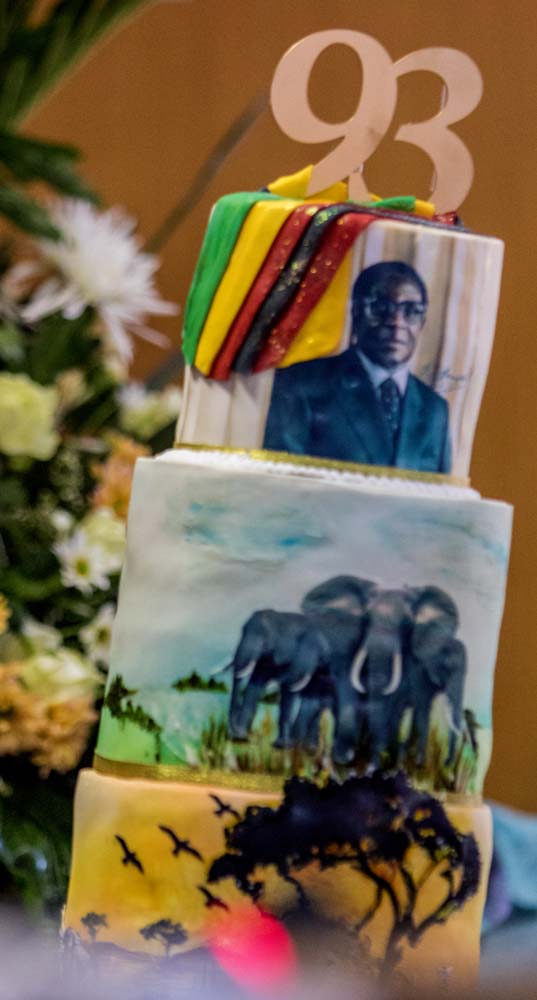 A picture taken on February 21, 2017 shows a cake bearing a portrait of Zimbabwe's President Robert Mugabe during a private ceremony to celebrate Mugabe's 93rd birthday in Harare.  Mugabe, the world's oldest national ruler, turned 93, using a long and occasionally rambling interview to vow to remain in power despite growing signs of frailty. / AFP PHOTO / Jekesai NJIKIZANA