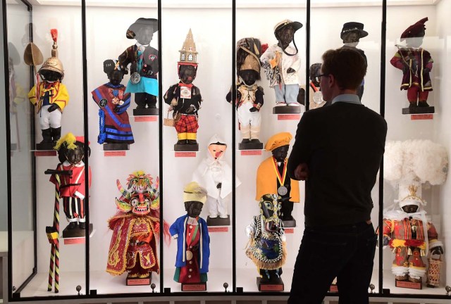 (FILES) This file photo taken on February 03, 2017 shows a visitor looking at part of an historical collection of outfits created for Brussel's landmark the Manneken Pis statue during a press preview of the GardeRobe Manneken Pis Museum (Manneken Pis Wardrobe Museum), in Brussels. Brussels' famous Manneken Pis statue has been cheekily urinating into its Baroque fountain for 400 years, and for about as long, fans around the world have dressed up the naked little boy in colourful costumes. / AFP PHOTO / EMMANUEL DUNAND