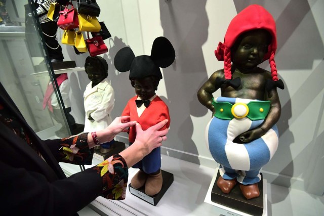 (FILES) This file photo taken on February 03, 2017 shows an official posing part of an historical collection of outfits created for Brussel's landmark the Manneken Pis statue during a press preview of the GardeRobe Manneken Pis Museum (Manneken Pis Wardrobe Museum), in Brussels. Brussels' famous Manneken Pis statue has been cheekily urinating into its Baroque fountain for 400 years, and for about as long, fans around the world have dressed up the naked little boy in colourful costumes. / AFP PHOTO / EMMANUEL DUNAND