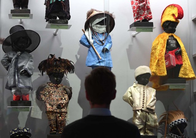 (FILES) This file photo taken on February 03, 2017 shows a visitor looking at part of an historical collection of outfits created for Brussel's landmark the Manneken Pis statue during a press preview of the GardeRobe Manneken Pis Museum (Manneken Pis Wardrobe Museum), in Brussels. Brussels' famous Manneken Pis statue has been cheekily urinating into its Baroque fountain for 400 years, and for about as long, fans around the world have dressed up the naked little boy in colourful costumes. / AFP PHOTO / EMMANUEL DUNAND