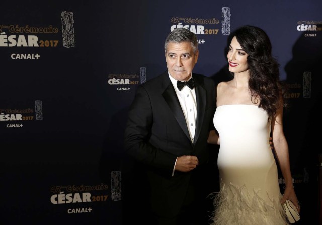 Actor George Clooney and his wife Amal pose as they arrive at the 42nd Cesar Awards ceremony in Paris, France, February 24, 2017. REUTERS/Gonzalo Fuentes