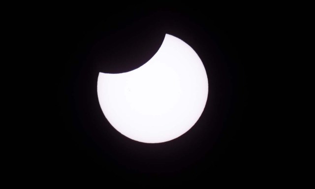 Picture taken on February 26, 2017 showing the moon moving to cover the sun for an annular solar eclipse, as seen from the Estancia El Muster, near Sarmiento, Chubut province, 1600 km south of Buenos Aires, Argentina, on February 26, 2017. Stargazers applauded as they were plunged into darkness Sunday when the moon passed in front of the sun in a spectacular "ring of fire" eclipse. / AFP PHOTO / ALEJANDRO PAGNI