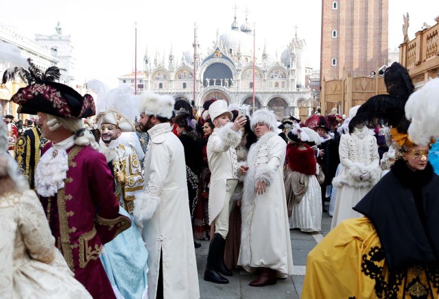 Revellers pose in Saint Mark's Square during the Venice Carnival, in Venice, Italy February 19, 2017. REUTERS/Alessandro Bianchi