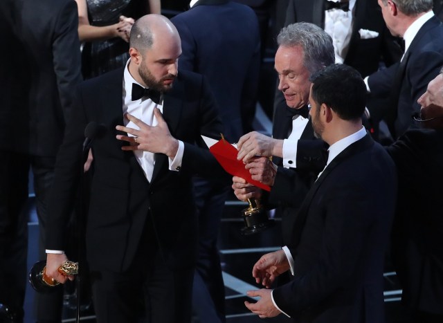 89th Academy Awards - Oscars Awards Show - Hollywood, California, U.S. - 26/02/17 - Jordan Horowitz (L) of "La La Land" talks with award presenter Warren Beatty and show host Jimmy Kimmel (R) after discovering that "Moonlight" won the Oscar for Best Picture instead of "La La Land." REUTERS/Lucy Nicholson