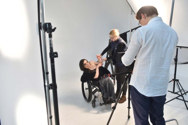 TO GO WITH AFP STORY BY OLGA SHYLENKO A camerawoman makes adjustments prior to a photo and video fashion shoot with Ukrainian model Alexandra Kutas, who is in a wheelchair from a very early age due to a spinal cord injury resulting from a doctor's mistake at birth, in Kiev on January 25, 2017. Kutas, 23, is Ukraine's first model with a disability to headline a runway event of this level, after covering a long and thorny path for her dream to come true. / AFP PHOTO / Sergei SUPINSKY / ?The erroneous mention[s] appearing in the metadata of this photo by Sergei SUPINSKY has been modified in AFP systems in the following manner: [a spinal cord injury resulting from a doctor's mistake at birth] instead of [cerebral palsy]. Please immediately remove the erroneous mention[s] from all your online services and delete it (them) from your servers. If you have been authorized by AFP to distribute it (them) to third parties, please ensure that the same actions are carried out by them. Failure to promptly comply with these instructions will entail liability on your part for any continued or post notification usage. Therefore we thank you very much for all your attention and prompt action. We are sorry for the inconvenience this notification may cause and remain at your disposal for any further information you may require.?