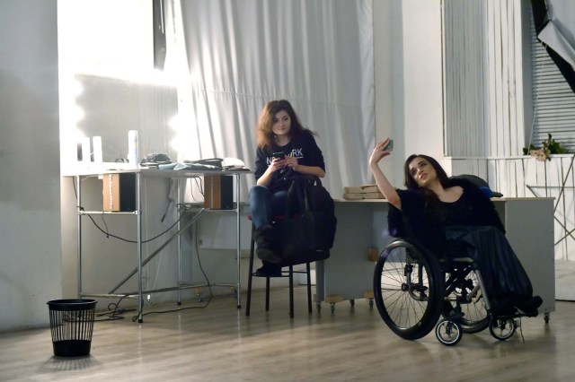 TO GO WITH AFP STORY BY OLGA SHYLENKO Ukrainian model Alexandra Kutas (R), who is in a wheelchair since from a very early age due to a spinal cord injury resulting from a doctor's mistake at birth, takes selfies during a break at a photo and video fashion shoot in Kiev on January 25, 2017. Kutas, 23, is Ukraine's first model with a disability to headline a runway event of this level, after covering a long and thorny path for her dream to come true. / AFP PHOTO / Sergei SUPINSKY / ?The erroneous mention[s] appearing in the metadata of this photo by Sergei SUPINSKY has been modified in AFP systems in the following manner: [a spinal cord injury resulting from a doctor's mistake at birth] instead of [cerebral palsy]. Please immediately remove the erroneous mention[s] from all your online services and delete it (them) from your servers. If you have been authorized by AFP to distribute it (them) to third parties, please ensure that the same actions are carried out by them. Failure to promptly comply with these instructions will entail liability on your part for any continued or post notification usage. Therefore we thank you very much for all your attention and prompt action. We are sorry for the inconvenience this notification may cause and remain at your disposal for any further information you may require.?