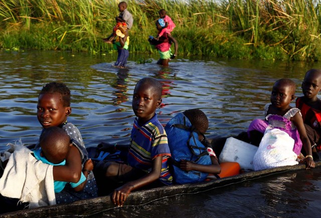 Children cross a body of water on a canoe  o reach a registration area prior to a food distribution carried out by the United Nations World Food Programme (WFP) in Thonyor, Leer state, South Sudan, February 25, 2017. REUTERS/Siegfried Modola