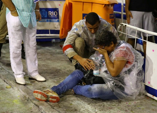 A photographer is assisted after an accident during the carnival parade at the Sambadrome in Rio de Janeiro, Brazil, February 26, 2017. REUTERS/Pilar Olivaresl, February 26, 2017. REUTERS/Pilar Olivares