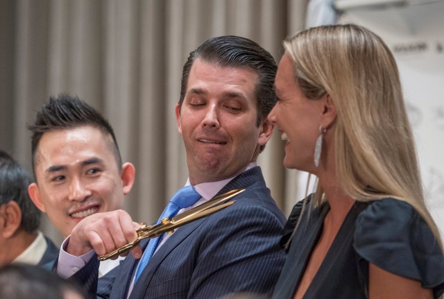 REFILE - CORRECTING NAME SPELLING Donald Trump Jr. (C) jokes around and motions with a large pair of scissors toward the throat of his wife Vanessa Trump (R) while Joo Kim Tiah (L) the CEO of TA Global, the owner and developer of Trump International Hotel and Tower Vancouver, looks on during the grand opening of the Trump International Hotel and Tower in Vancouver, British Columbia, Canada February 28, 2017. REUTERS/Nick Didlick     TPX IMAGES OF THE DAY