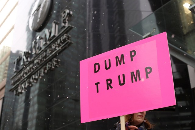 A protester holds a sign during the grand opening of the Trump International Hotel and Tower in Vancouver, British Columbia, Canada February 28, 2017. REUTERS/David Ryder TPX IMAGES OF THE DAY