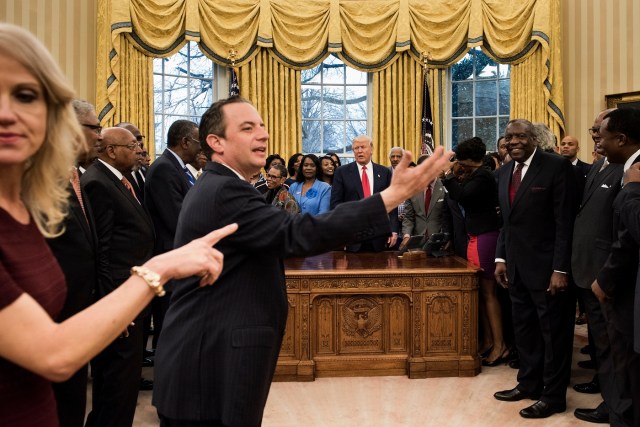 Counselor to the President Kellyanne Conway (L) and White House Chief of Staff Reince Priebus ((2nd-L) direct leaders of historically black universities and colleges for a photo with US President Donald Trump in the Oval Office of the White House before a meeting with US Vice President Mike Pence February 27, 2017 in Washington, DC. / AFP PHOTO / Brendan Smialowski