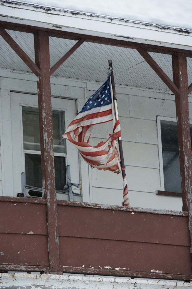 A torn US flag flies on a house near the US/Canada border March 2, 2017, in the border town of Estcourt, Maine. / AFP PHOTO / DON EMMERT