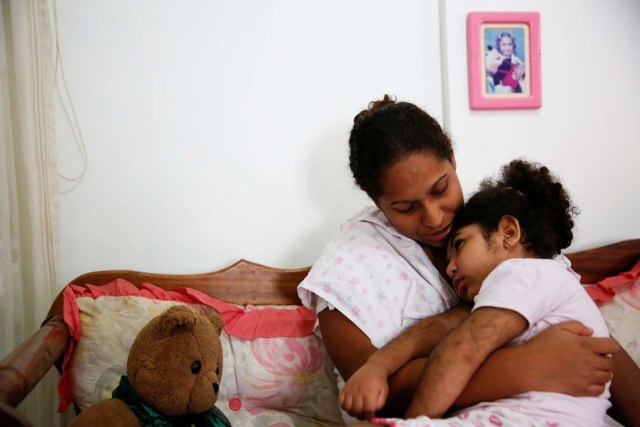 Lusnay Echezuria, embraces her daughter Arioska Torres, 3, a neurological patient being treated with anticonvulsants, at their house in Caracas, Venezuela January 30, 2017. REUTERS/Carlos Garcia Rawlins   SEARCH "EPILEPSY CARACAS" FOR THIS STORY. SEARCH "WIDER IMAGE" FOR ALL STORIES.