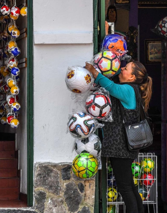 A tourist buys a ball at a ball factory in Mongui, in the Colombian department of Boyaca, on February 13, 2017. Mongui, in the central mountains of Colombia, has about 20 football factories that make balls mainly for football and micro-football. About a quarter of the town's 4,900 inhabitants work in these factories. / AFP PHOTO / Luis ACOSTA