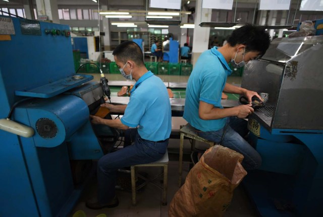 (FILES) This file photo taken on September 14, 2016 shows workers at the Huajian shoe factory, where about 100,000 pairs of Ivanka Trump-branded shoes have been made over the years amongst other brands, in Dongguan in south China's Guangdong province. In his January inauguration speech, US President Donald Trump made a seemingly straightforward pledge: "We will follow two simple rules: buy American and hire American." His daughter is the exception: even as he spoke, at least eight shipments of Ivanka Trump-branded shoes, bags and clothes -- more than 53.5 tonnes -- were steaming towards American ports from China, according to US Customs bills of lading examined by AFP. / AFP PHOTO / Greg Baker / TO GO WITH China-US-politics-economy-trade-Trump, FOCUS by Ben DOOLEY