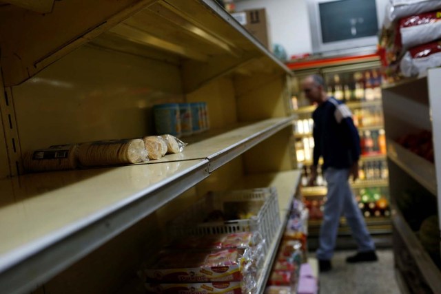A man walks past empty shelves at a supermarket in Caracas, Venezuela March 9, 2017. REUTERS/Carlos Garcia Rawlins