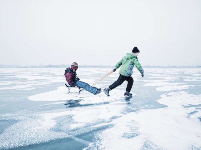 PRIMER LUGAR, NIÑOS "La foto fue filmada en la ciudad de Harbin, provincia de Heilongjiang en China. Dos niños jugaban con un trineo casero en el congelado río Songhua ".