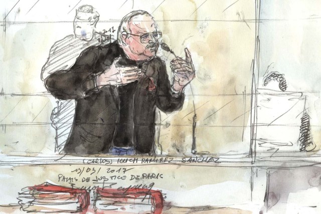 A court sketch made on March 13, 2017 shows Ilyich Ramirez Sanchez, known as Carlos the Jackal, gesturing during his trial in France for the deadly bombing of the Drugstore Publicis, a busy shop once located in Saint-Germain-des-Pres in the French capital Paris more than 40 years ago. Carlos, 67, a Venezuelan whose real name is Ilyich Ramirez Sanchez was arrested in the Sudanese capital Khartoum in 1994 by elite French police. He is already serving a life sentence for the murders of two policemen killed in Paris in 1975 and that of a Lebanese revolutionary. He was also found guilty of four bombings in Paris and Marseille in 1982 and 1983, some targeting trains, which killed a total of 11 people and injured nearly 150. / AFP PHOTO / Benoit PEYRUCQ