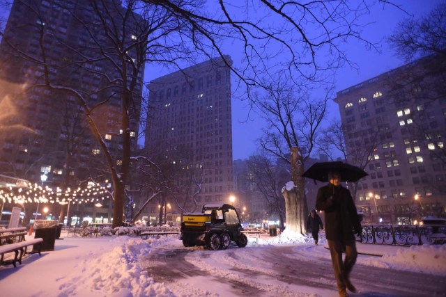 A man clears the sidewalk near Madison Square Park at the foot of the Flatiron building in Manhattan during a snowstorm in New York on March 14, 2017. Winter Storm Stella dumped snow and sleet Tuesday across the northeastern United States where thousands of flights were canceled and schools closed, but appeared less severe than initially forecast. After daybreak the National Weather Service (NWS) revised down its predicted snow accumulation for the city of New York, saying that the storm had moved across the coast. / AFP PHOTO / ERIC BARADAT