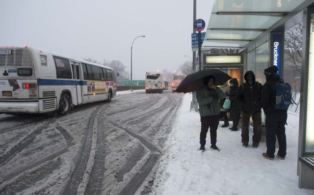 Passengers wait to board buses in the Bronx Borough March 14, 2017 in New York. Winter Storm Stella dumped snow and sleet Tuesday across the northeastern United States where thousands of flights were canceled and schools closed, but appeared less severe than initially forecast. After daybreak the National Weather Service (NWS) revised down its predicted snow accumulation for the city of New York, saying that the storm had moved across the coast. / AFP PHOTO / DON EMMERT