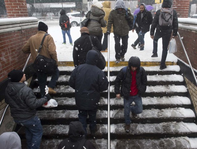 Passengers enter and exit the Hunts Point subway station in the Bronx Borough March 14, 2017 in New York. Winter Storm Stella dumped snow and sleet Tuesday across the northeastern United States where thousands of flights were canceled and schools closed, but appeared less severe than initially forecast. After daybreak the National Weather Service (NWS) revised down its predicted snow accumulation for the city of New York, saying that the storm had moved across the coast. / AFP PHOTO / DON EMMERT