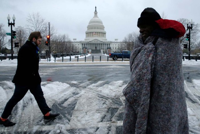 Men walk in the frozen rain near the U.S. Capitol, in Washington, U.S., March 14, 2017. REUTERS/Jonathan Ernst