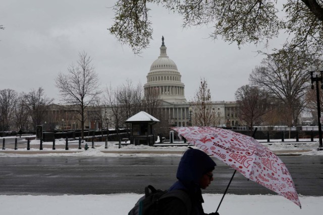 Commuters walk through the snow outside the Capitol Building in Washington, D.C., U.S. March 14, 2017. REUTERS/Aaron P. Bernstein