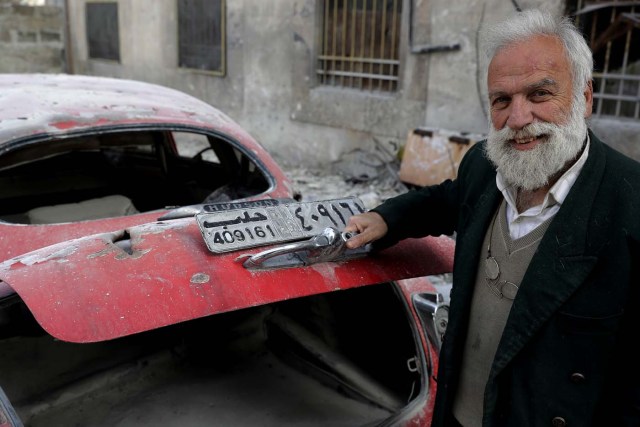 A picture taken on March 9, 2017, shows 70-year-old Mohammed Mohiedin Anis, or Abu Omar, opening the trunk of his 1949 Hudson Commodor outside his home in Aleppo's formerly rebel-held al-Shaar neighbourhood.  / AFP PHOTO / JOSEPH EID