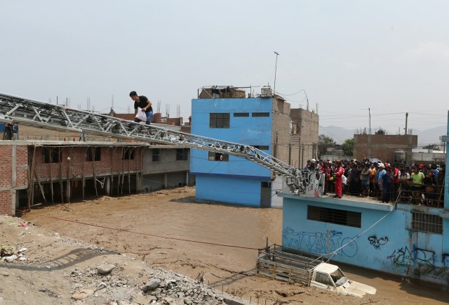 REFILE - CORRECTING NAME OF THE RIVER Rescue workers use an extension ladder to evacuate stranded residents after the Huaycoloro river overflooded its banks sending torrents of mud and water rushing through the streets in Huachipa, Peru, March 17, 2017. REUTERS/Guadalupe Pardo