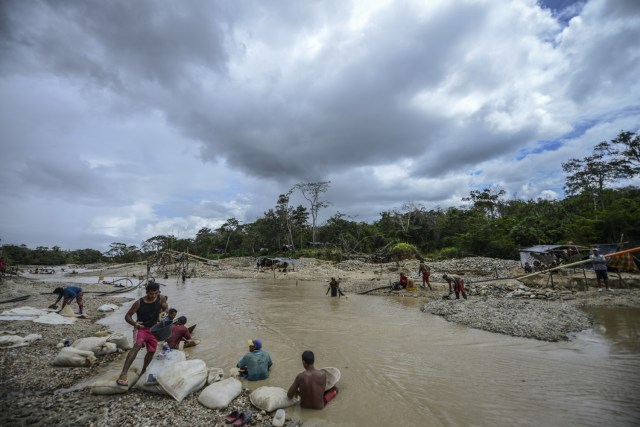 Men work at Nacupay gold mine on the banks of a river in El Callao, Bolivar state, southeastern Venezuela on February 24, 2017. Although life in the mines of eastern Venezuela is hard and dangerous, tens of thousands from all over the country head for the mines daily in overcrowded trucks, pushed by the rise in gold prices and by the severe economic crisis affecting the country, aggravated recently by the drop in oil prices. / AFP PHOTO / JUAN BARRETO