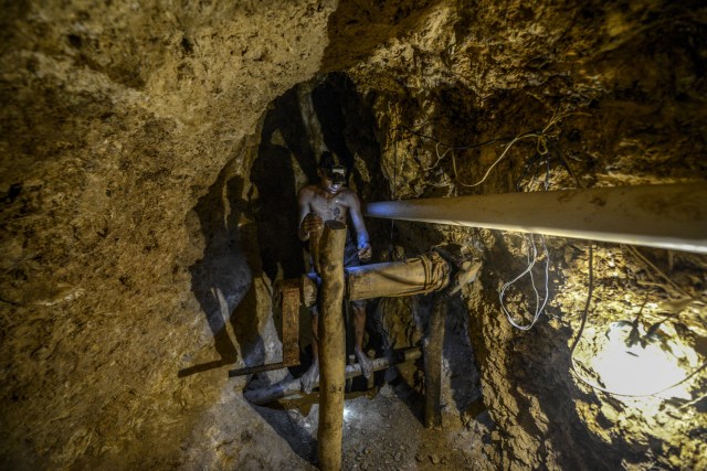 Ender Moreno looks for gold stones at La Culebra gold mine, in El Callao, Bolivar state, southeastern Venezuela on March 1, 2017. Although life in the mines of eastern Venezuela is hard and dangerous, tens of thousands from all over the country head for the mines daily in overcrowded trucks, pushed by the rise in gold prices and by the severe economic crisis affecting the country, aggravated recently by the drop in oil prices. / AFP PHOTO / JUAN BARRETO