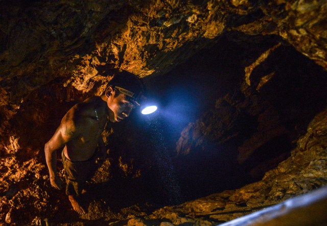 Ender Moreno looks for gold at La Culebra gold mine in El Callao, Bolivar state, southeastern Venezuela on March 1, 2017. Although life in the mines of eastern Venezuela is hard and dangerous, tens of thousands from all over the country head for the mines daily in overcrowded trucks, pushed by the rise in gold prices and by the severe economic crisis affecting the country, aggravated recently by the drop in oil prices. / AFP PHOTO / JUAN BARRETO / TO GO WITH AFP STORY by Maria Isabel SANCHEZ