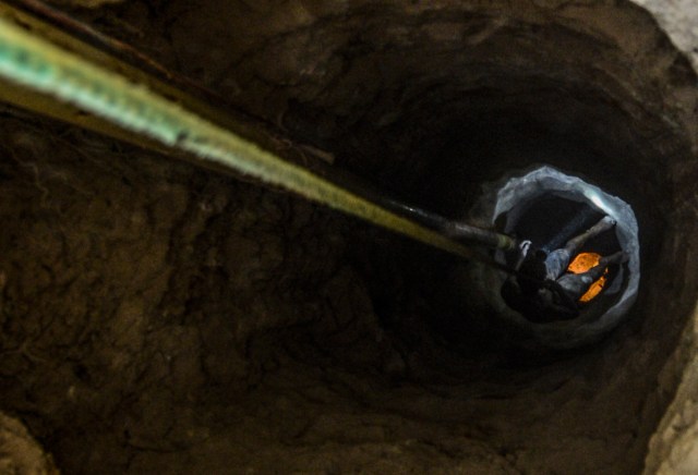 Ender Moreno drops down into La Culebra gold mine in El Callao, Bolivar state, southeastern Venezuela on March 1, 2017. Although life in the mines of eastern Venezuela is hard and dangerous, tens of thousands from all over the country head for the mines daily in overcrowded trucks, pushed by the rise in gold prices and by the severe economic crisis affecting the country, aggravated recently by the drop in oil prices. / AFP PHOTO / JUAN BARRETO / TO GO WITH AFP STORY by Maria Isabel SANCHEZ