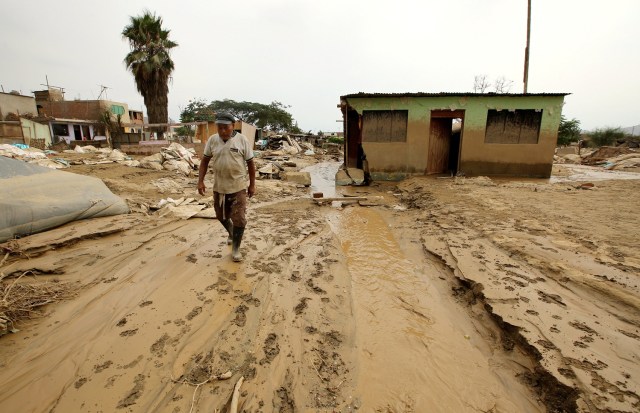 A man walks next to his destroyed home, after rivers breached their banks due to torrential rains, causing flooding and widespread destruction in Cajamarquilla, Lima, Peru, March 18,  2017. REUTERS/Mariana Bazo     TPX IMAGES OF THE DAY
