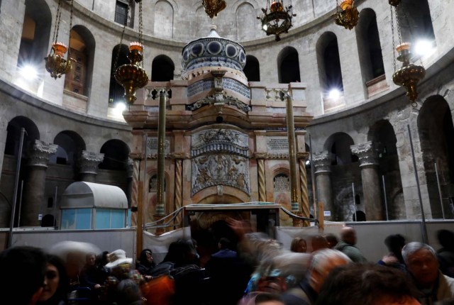 Visitors stand near the newly restored Edicule, the ancient structure housing the tomb, which according to Christian belief is where Jesus's body was anointed and buried, seen at the completion of months of restoration works, at the Church of the Holy Sepulchre in Jerusalem's Old City March 20, 2017. REUTERS/Ronen Zvulun
